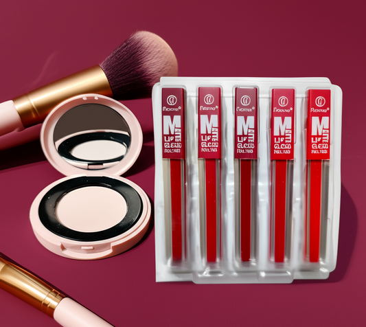 Makeup set with lip glosses, a compact mirror, and brushes on a red background